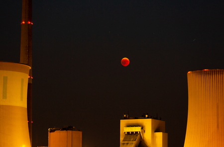Lunar eclipse - it seems as if the red moon is directly above the power plant - GroÃŸkrotzenburg,...