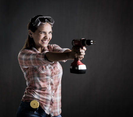 Beautiful woman holding a power drillの写真素材
