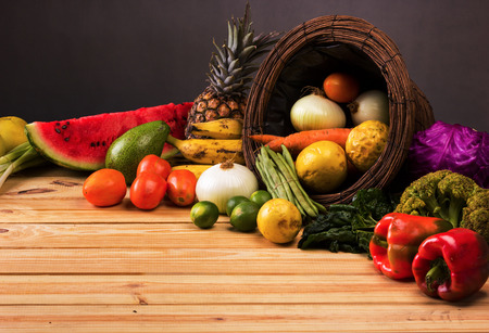 basket and table full of colorful fruits and vegetables that were purchased on the market, dark backgroundの写真素材