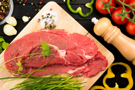 Beef steak and ingredients for preparing on black backgroundの写真素材