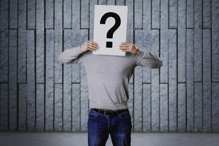 Man with question symbol on his faceの写真素材