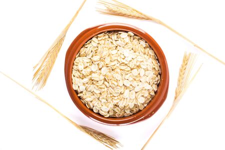 Oat flakes, uncooked oats in bowl on white background , Concept of healthy eating, vegan food, healthy food, breakfast.の写真素材