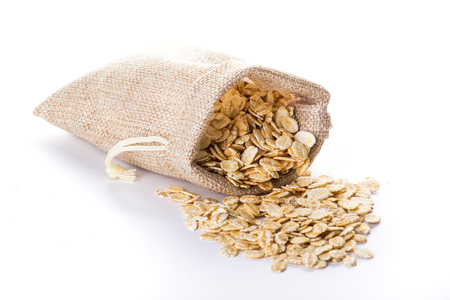 Oat flakes, uncooked oats in bowl on white background , Concept of healthy eating, vegan food, healthy food, breakfast.の写真素材