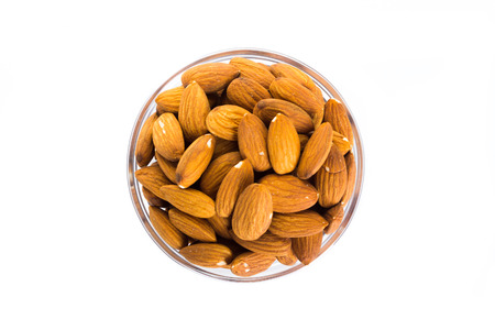 Group of almonds placed in a bowl on a white background. top viewの写真素材