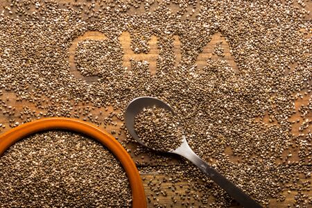 Group of chia seeds in a bowl on a wooden table.の写真素材
