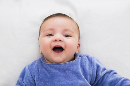 close up of smiling baby lying in his cribの写真素材