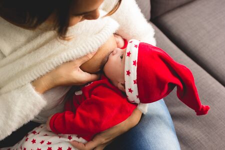 mother feeding her son with Christmas costumeの写真素材