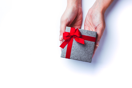 woman's hands holding a red gift box for valentines dayの写真素材