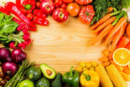 Frame full of fruits and vegetables on a wooden table seen from above with a negative space to place text or logo.の写真素材