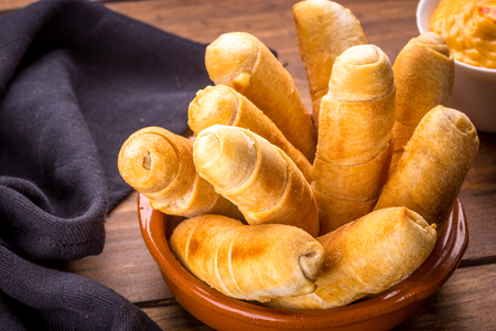 Several fingers of cheese on a wooden background.の写真素材