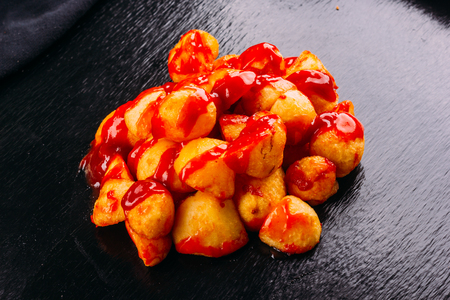 Typical spanish food, patatas bravas, fried potatoes with a hot sauce, on a dark backgroundの写真素材