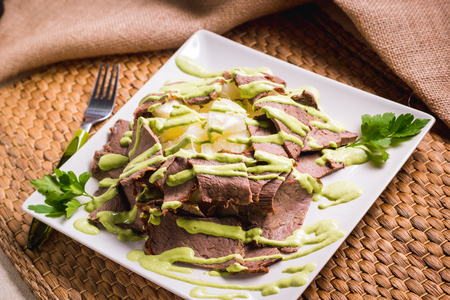 grilled sliced steak and patatoes on white plate, top viewの写真素材