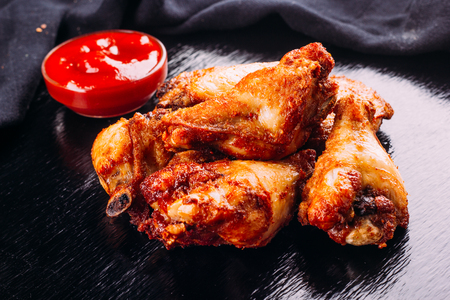 fried chicken on a black background and ketchup on the sideの写真素材