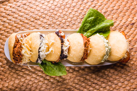 Different types of arepas, meat, black beans, cheese, fried plantain, typical South American foodの写真素材