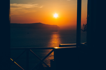Beautiful sunset on Santorini island, Greece. Romantic landscape with sea view, orange colorの写真素材