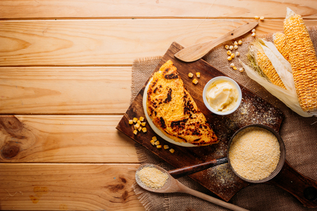 Typical Venezuelan cuisine, Top view of a wooden table with several ingredients for the preparation of Cachapas with cheese, corn, butter, ground corn and white cheeseの写真素材
