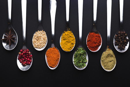 Spices and condiments for cooking on a black backgroundの写真素材
