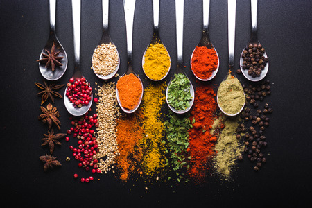 Spices and condiments for cooking on a black backgroundの写真素材