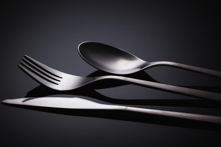Set of stainless steel cutlery on a black reflective background, Restaurant conceptの写真素材