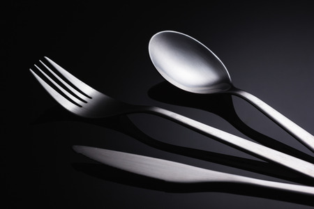 Set of stainless steel cutlery on a black reflective background, Restaurant conceptの写真素材