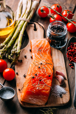 Recipe of salmon with various spices and vegetables on a rustic wooden backgroundの写真素材