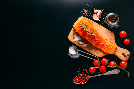 Delicious Salmon fillet with various spices on black backgroundの写真素材