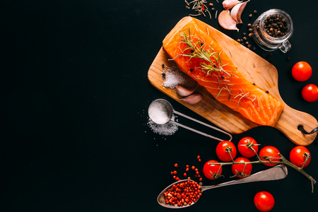 Delicious Salmon fillet with various spices on black backgroundの写真素材