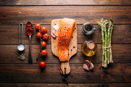Recipe of salmon with various spices and vegetables on a rustic wooden backgroundの写真素材