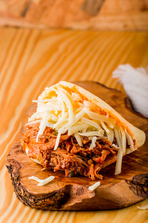 Roasted beef arepa on a wooden tableの写真素材