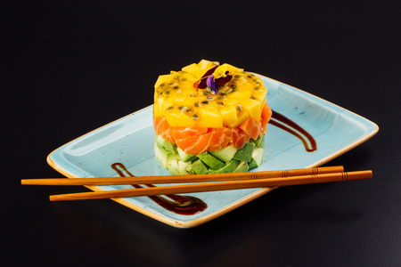 Delicious avocado, salted salmon and mango tartar, served, dark backgroundの写真素材