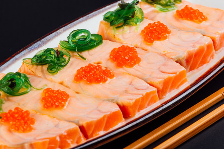 Tataki of salmon seasoned with yuzu and accompanied with salmon roe and seaweedの写真素材