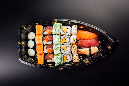 Japanese cuisine. Sushi set on a plastic ship over dark background.の写真素材