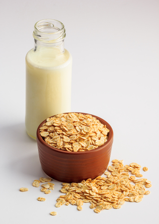 Oat milk and bowl with oat flakes on a white backgroundの写真素材