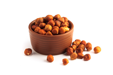 bowl full of hazelnuts isolated on a white backgroundの写真素材
