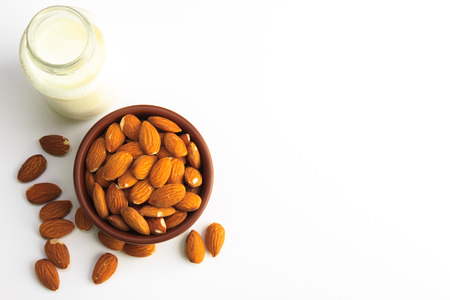 Top view of Milk and bowl of almonds isolated on a white backgroundの写真素材