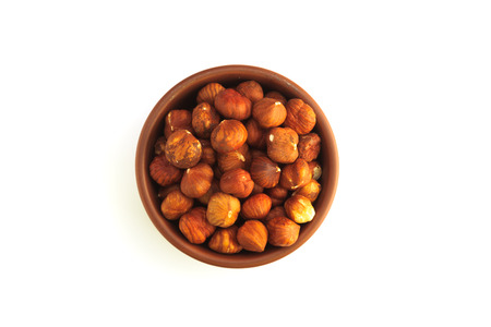 bowl full of hazelnuts isolated on a white backgroundの写真素材