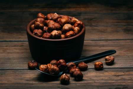 bowl full of hazelnuts on a wooden tableの写真素材