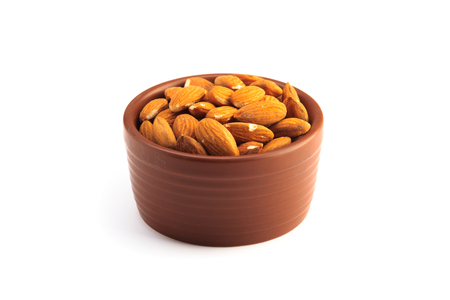 Bowl full of almonds and isolated on a white backgroundの写真素材