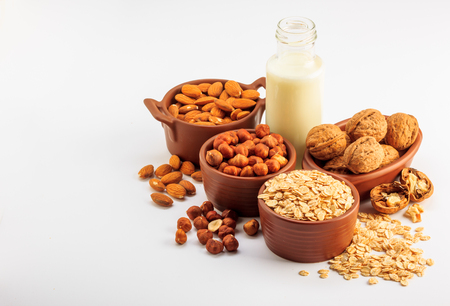 Different types of vegan milk, almond milk, oat milk, hazelnut milk and walnut milk on a white backgroundの写真素材