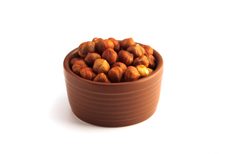 bowl full of hazelnuts isolated on a white backgroundの写真素材