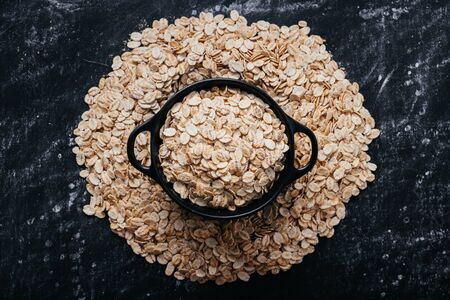 Pile of oat flakes on a black background.