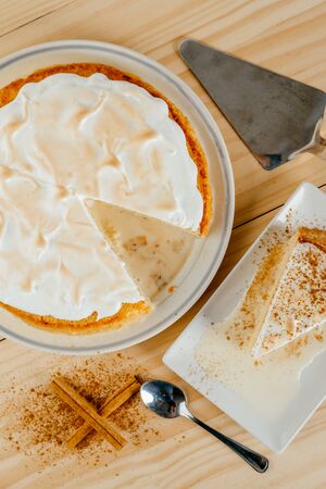 Top view of a delicious three milk cake and a little cinnamon on a pine wood background, typical Latin American dessertの写真素材