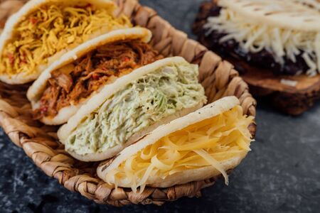 Top view of various types of typical Venezuelan arepas in a woven basketの写真素材