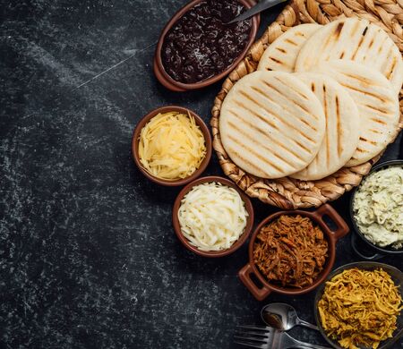 Top view of typical Latin American food. Group of arepas and different types of ingredients to fill themの写真素材