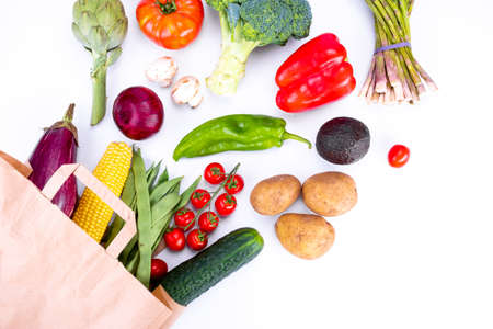 Top view of Paper bag with fresh vegetables on white background, grocery shoppingの写真素材
