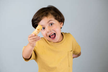 Boy enjoying tequeÃ±os, Venezuelan appetizerの写真素材
