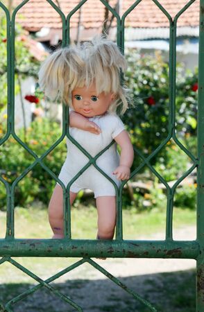 doll hanged on metal  doorsの写真素材