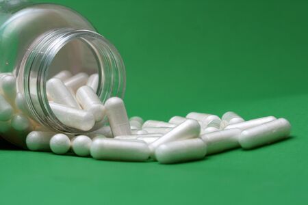 Pills spilling out of pill bottleの写真素材