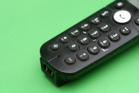 Black wireless phone on green backの写真素材