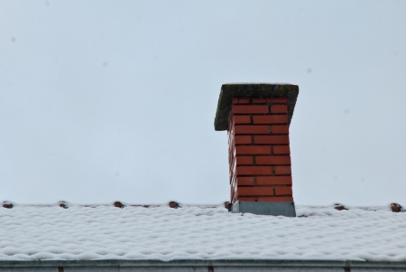 chimney in winter with snowの写真素材